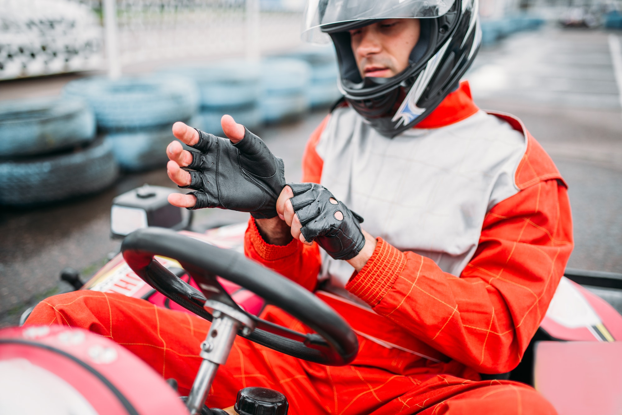 Go-kart driver in helmet on karting speed track